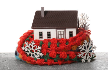 House model with scarf and snowflakes on table against white background. Heating concept