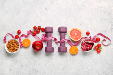 Bowls with healthy food, dumbbells and measuring tape on light background. Diet concept