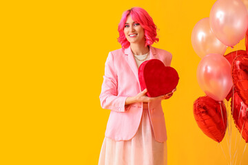 Fototapeta premium Stylish woman with bright hair, gift and air balloons on color background. Valentine's Day celebration