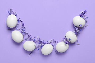 Composition with Easter eggs and gypsophila flowers on lilac background