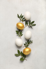 Beautiful Easter eggs and plant leaves on light background