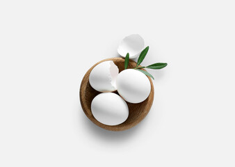 Bowl with Easter eggs on white background