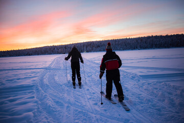 Skiing on the frozen lake at Torassieppi at sunset, Lapland, Finland