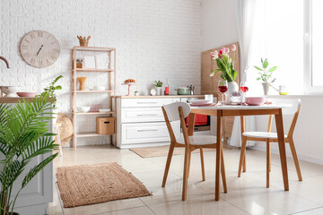 Dining table with setting for International Women's Day celebration in light kitchen interior