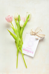 Greeting card with text 8 MARCH INTERNATIONAL WOMEN'S DAY, gift box and tulips on light background