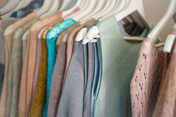 a lot of multi-colored knitwear on a rack in the showroom