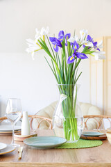 Dining table with setting and beautiful iris flowers for International Women's Day celebration