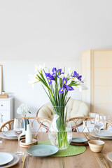 Dining table with setting and beautiful iris flowers for International Women's Day celebration