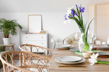 Vase with iris flowers on dining table served for International Women's Day celebration in room