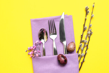 Beautiful cutlery for Easter celebration on yellow background