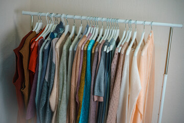 a lot of multi-colored knitwear on a rack in the showroom