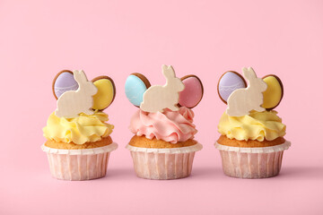 Tasty Easter cupcakes on pink background