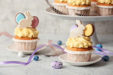 Tasty Easter cupcakes and eggs on light background, closeup