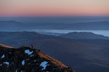 Hiking Ben Lomond 974m summit at sunset in the mountains of Loch Lomond and the Trossachs National...