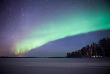 Foto auf Acrylglas Northern Lights (aurora borealis) over a snow covered icy frozen lake in winter in Finnish Lapland, inside Arctic Circle in Finland © Matthew