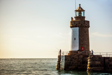 Fishing from the lighthouse in St Peter Port Harbour, Guernsey, Channel Islands, United Kingdom