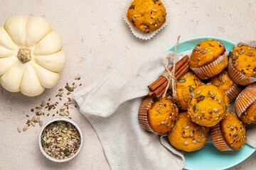 Pumpkin muffins with spices and seeds on light background. Copy space. Autumn, halloween, thanksgiving baking concept.