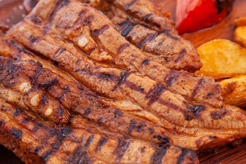 Delicious barbecued ribs on wooden cutting board