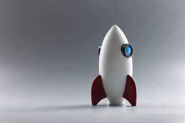 Rocket toy model stand on grey surface, rocketship as symbol for business project
