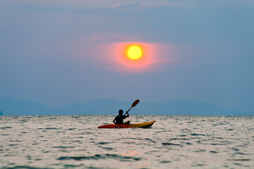 One Man Kayaking at Sunset on Tropical Ao Phra Nang Beach, Railay (Rai Leh), South Thailand,...