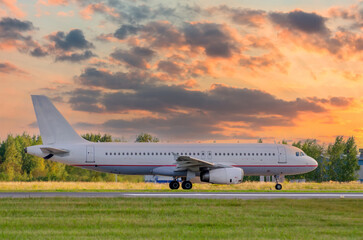 Sunset view of airplane on airport runway before take off.