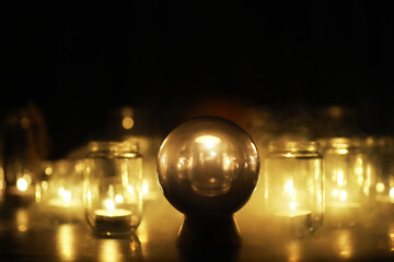 Black background with a ball and candles. Divination and prediction of fate.