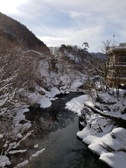 Snow Covered Buildings and Stream of Japanese Hot Springs Town Minakami Gunma Japan