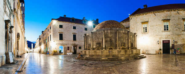 Panoramic photo of Dubrovnik Old Town at night, including Onofrio Fountain, Stradun and Dubrovnik City Bell Tower, Croatia - obrazy, fototapety, plakaty