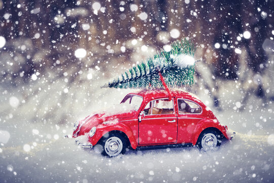 Kostanay, Kazakhstan 2022.Red Volkswagen beetle with a spruce on roof in a winter, snow covered pine forest.