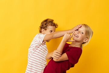 two joyful children cuddling fashion childhood entertainment yellow background