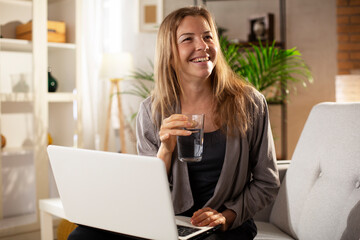 Girl holding a glass of water. Smiling girl drinking water.