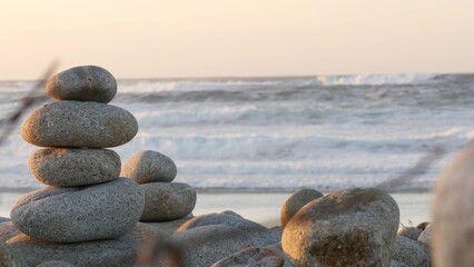Rock balancing on pebble beach, Monterey 17-mile drive, California coast, USA. Stable pyramid...