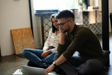 Colleagues in office. Businesswoman and businessman sitting on the floor. Colleagues working on the project