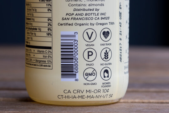 Portland, OR, USA - Sep 30, 2021: Various labelings seen on a bottle of Pop and Bottle brand almond latte - Vegan, Fair Trade, Paleo, No Gluten, Non-GMO, Women Founded, California Refund Value (CRV).