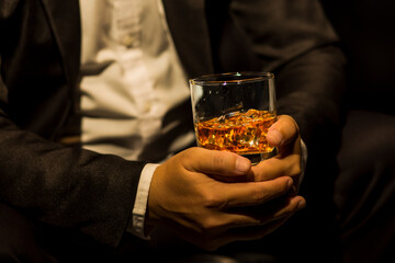 Closeup businessmen holding a glass of whiskey