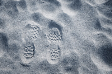 The imprint of two shoes on the sand, resembling the surface of the moon - Powered by Adobe