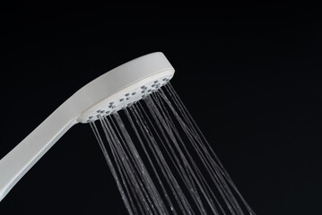 Water pouring from white shower head.