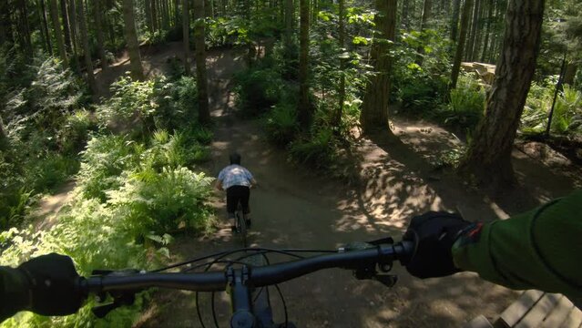 Mountain Bike Park POV Following Friend Off Wood Drop Obstacle