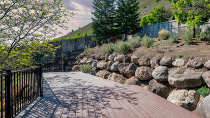 Panorama Puffy clouds at sunset Hillside wooden deck with metal railings and a view of a slope o