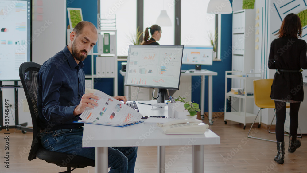 Poster business manager using computer and papers with charts for marketing strategy. entrepreneur with cor