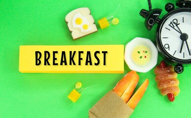 alarm clock and food with the word breakfast. breakfast concept