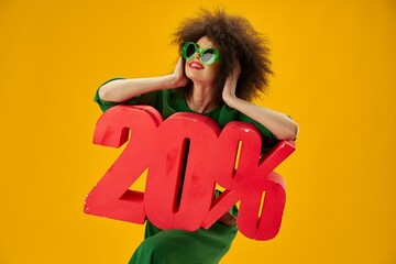 Portrait of a charming lady green dress afro hairstyle dark glasses twenty percent in hands color...