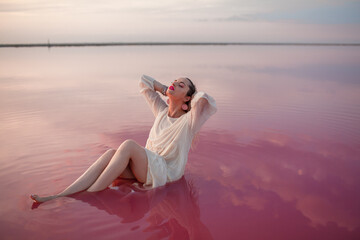 Fototapeta na wymiar Pretty woman walking in the beach of salt pink lake