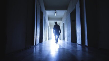 The handsome man looking for something in a dark corridor