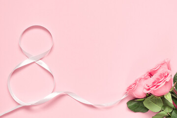 Number eight made of white ribbon and roses on pink background. Card for 8 March, woman day. Copy space, mock up, banner