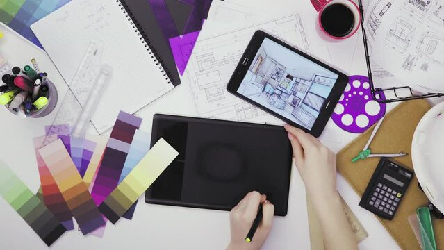 Top view of a creative designer using a graphic tablet while working at his desk