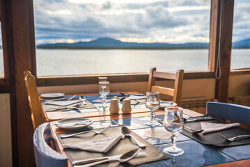Restaurant table set up with beautiful view of lake and mountains, Puerto Natales, Chilean Patagonia, Chile, South America