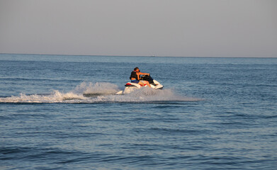 Teen age boy skiing on water scooter. Young man on personal watercraft in tropical sea. Active...