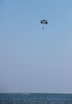 Parasailing is a popular type of outdoor activity at the sea. Parachute soars in the sky over the Sea with tourists