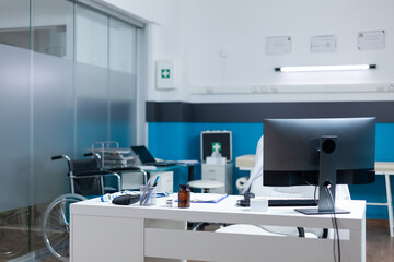 Empty medical office with nobody in it ready for disease consultation equipped with professional modern contemporary furniture. Examination room having sickness documents on table. Medicine services